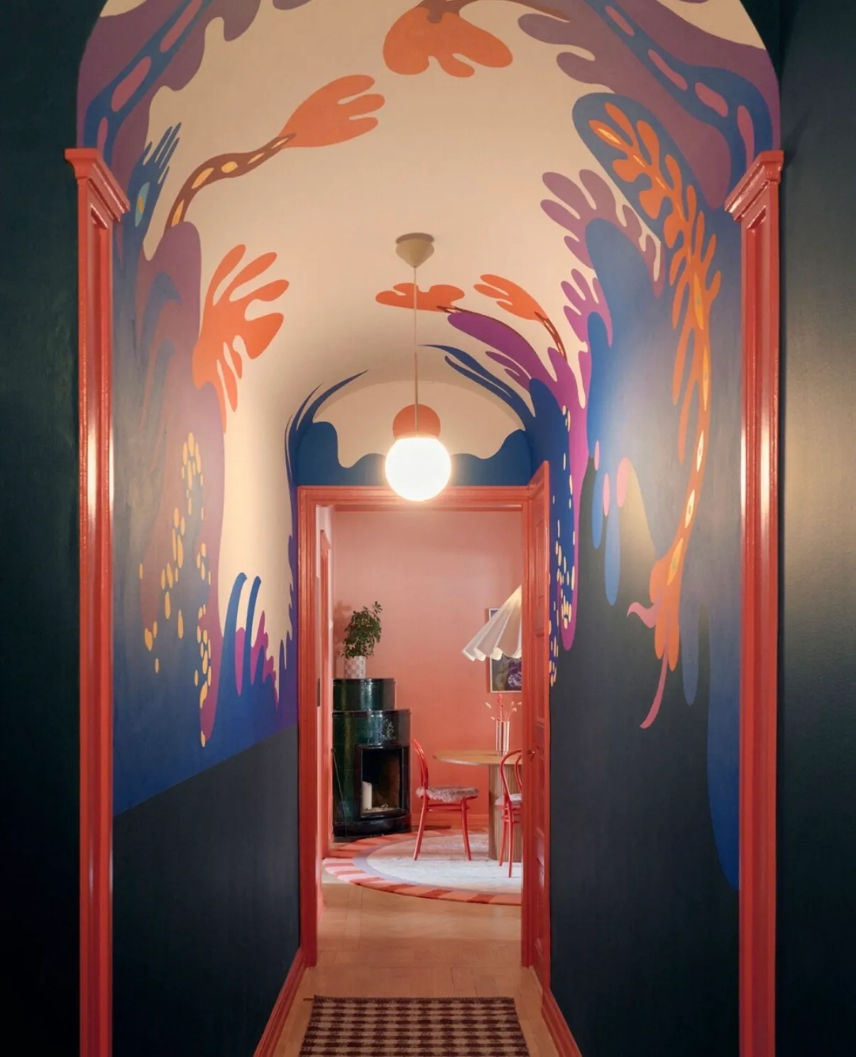Muralmålning av Amandah L'Narte — växtformer i orange, blått och lila över valv och väggar i en hall